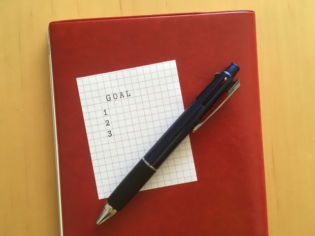 赤い手帳とペンとメモ用紙