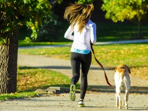 犬とジョギンングしていうる女性